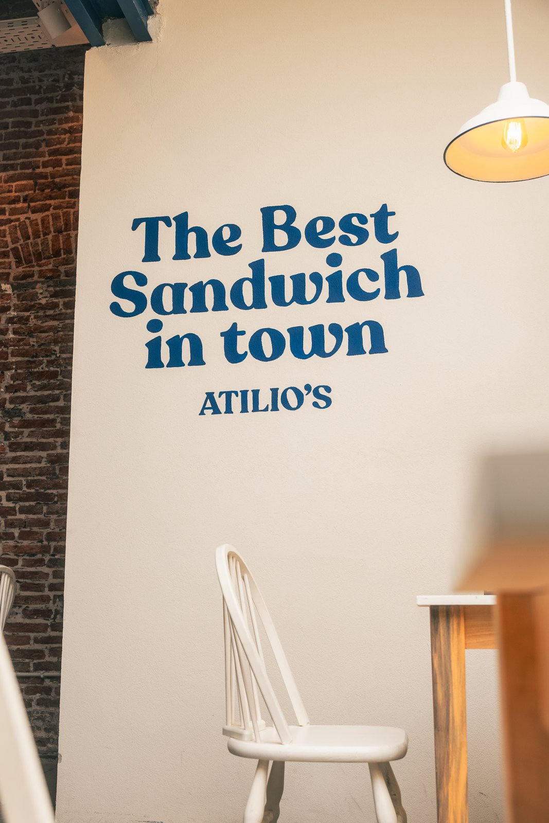 Pared de una sucursal de Atilio's pintada con la frase The Best Sandwich in town